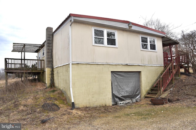 view of side of property with stairs, a deck, and a pergola