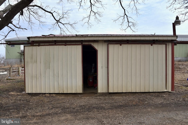 view of outdoor structure featuring fence and an outbuilding