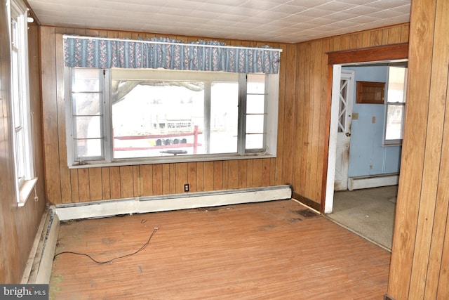 empty room with a baseboard heating unit and a wealth of natural light