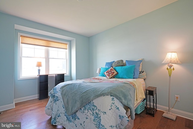 bedroom with baseboards and wood finished floors