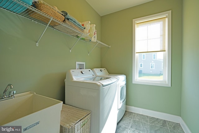 washroom with light tile patterned floors, a sink, laundry area, independent washer and dryer, and baseboards