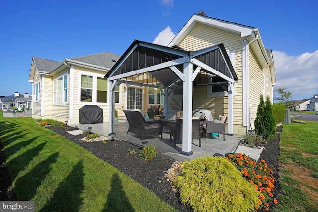 back of property with a patio, a shingled roof, outdoor lounge area, a sunroom, and a yard