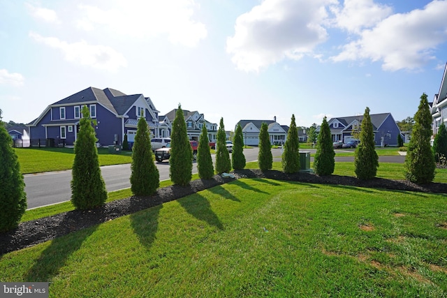 view of property's community with a residential view and a lawn