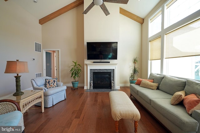 living room featuring a fireplace, wood finished floors, visible vents, and baseboards