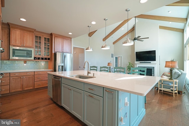 kitchen with stainless steel appliances, dark wood-type flooring, a sink, open floor plan, and an island with sink