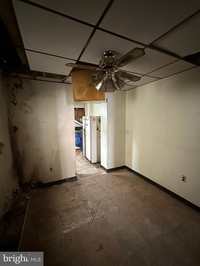 spare room featuring a ceiling fan and baseboards