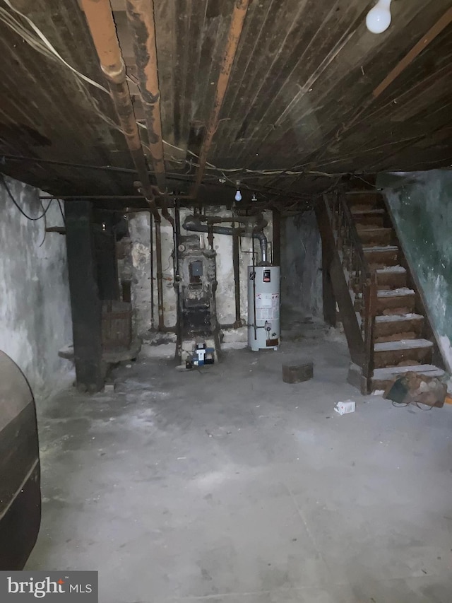 unfinished below grade area with heating fuel, stairs, and water heater