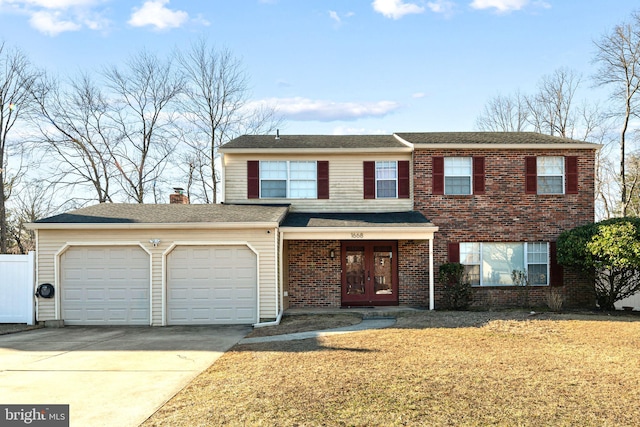 traditional home featuring french doors, brick siding, concrete driveway, an attached garage, and a front lawn