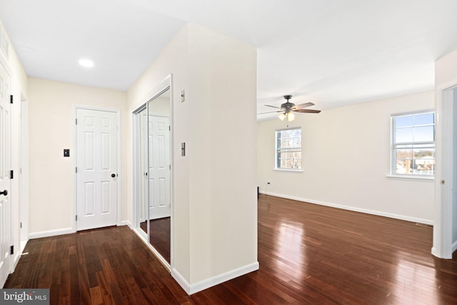 corridor with baseboards and hardwood / wood-style floors