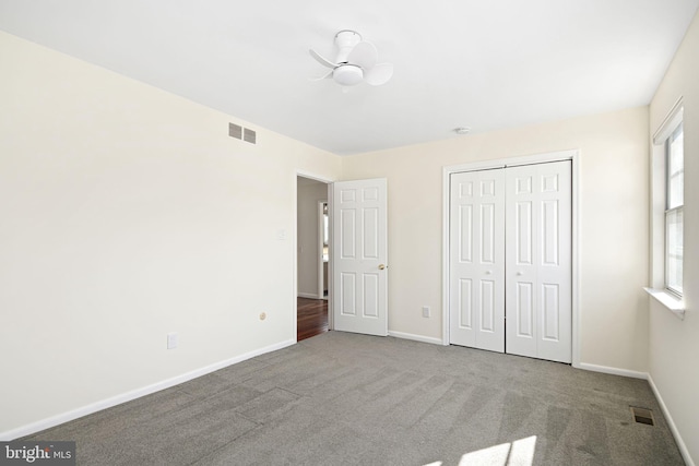 unfurnished bedroom with carpet floors, a closet, visible vents, and baseboards