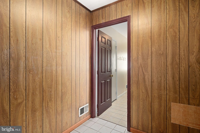 hall featuring visible vents, wood walls, and light tile patterned flooring