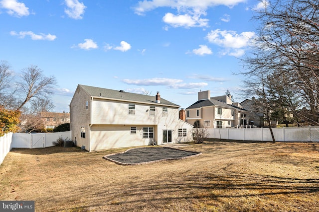 rear view of house with a fenced backyard, cooling unit, and a lawn