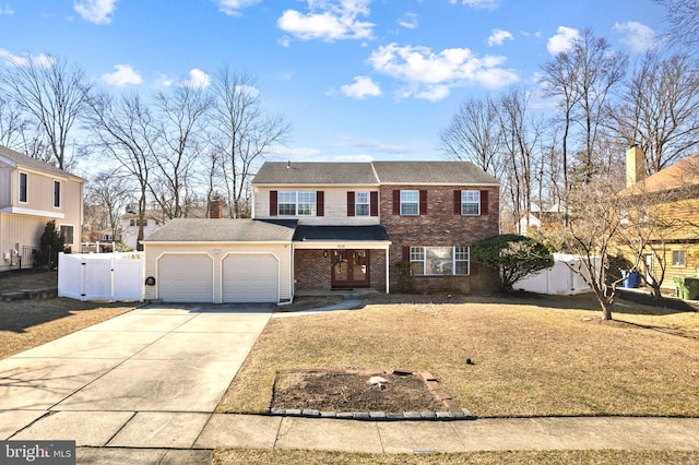 view of front of house with brick siding, concrete driveway, an attached garage, a gate, and fence