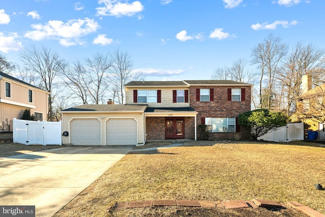 traditional-style house featuring concrete driveway, an attached garage, a gate, fence, and brick siding