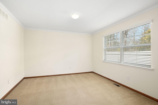 empty room with visible vents, baseboards, crown molding, and light colored carpet