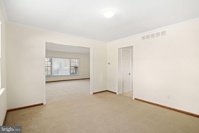 carpeted spare room featuring ornamental molding, visible vents, and baseboards