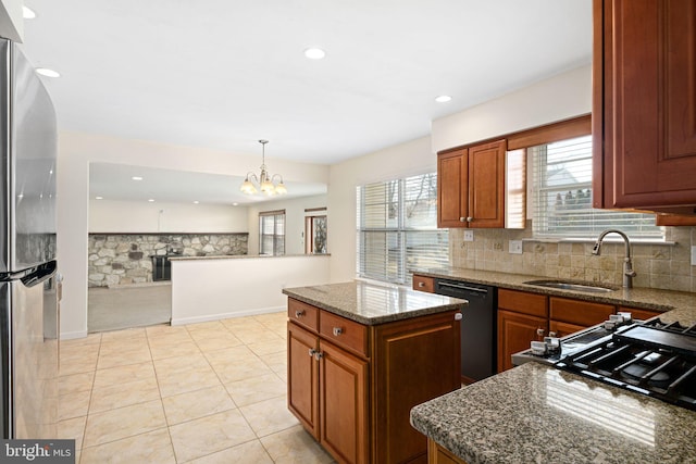 kitchen featuring a sink, tasteful backsplash, dishwasher, and freestanding refrigerator