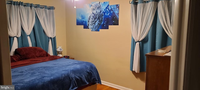 bedroom with baseboards and wood finished floors