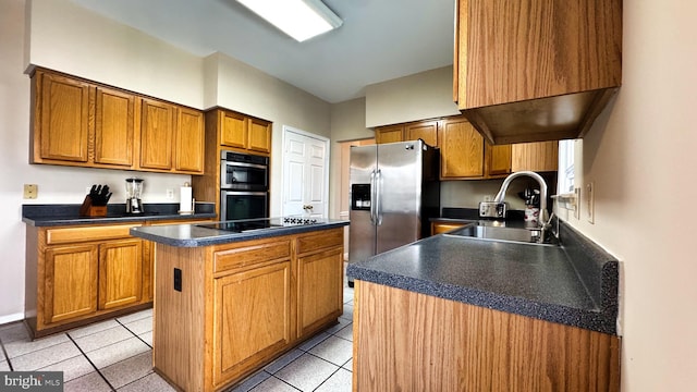 kitchen with light tile patterned floors, a kitchen island, stainless steel appliances, and a sink