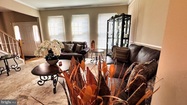 living area with plenty of natural light, stairs, and crown molding