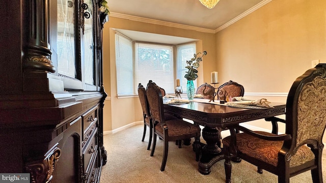 dining space featuring light colored carpet, crown molding, and baseboards