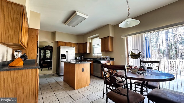 kitchen with dark countertops, light tile patterned floors, a center island, and stainless steel appliances