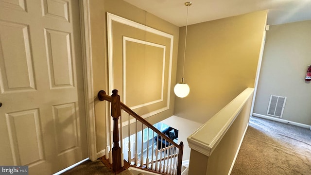 stairs with visible vents, carpet floors, and baseboards