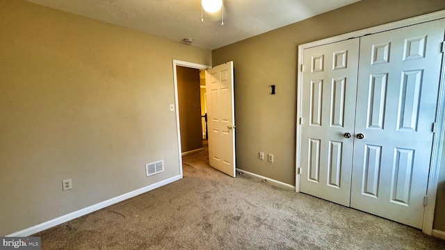 unfurnished bedroom featuring a closet, visible vents, baseboards, and carpet