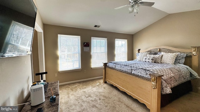 carpeted bedroom with a ceiling fan, vaulted ceiling, baseboards, and visible vents