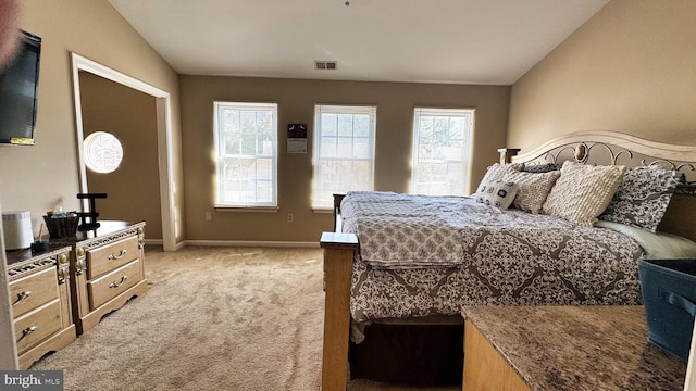 bedroom with lofted ceiling, baseboards, visible vents, and light carpet