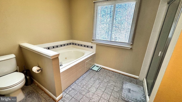 full bathroom with baseboards, a stall shower, toilet, and a garden tub