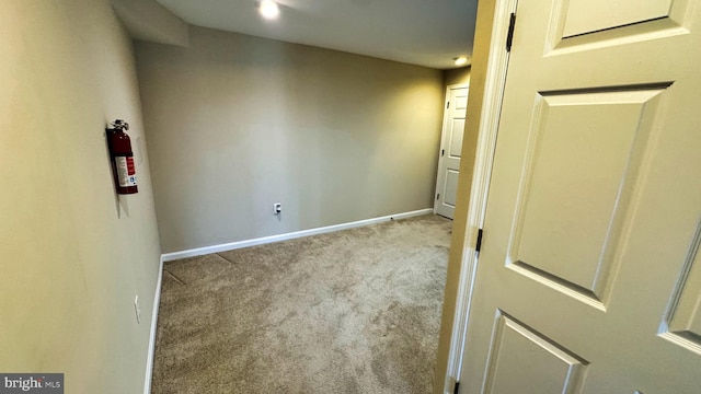 spare room featuring carpet flooring and baseboards