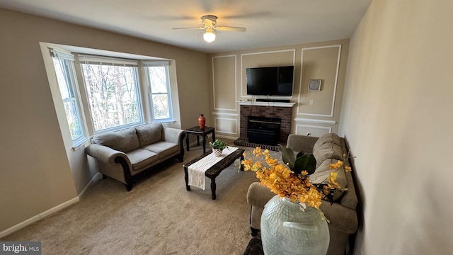 living room with ceiling fan, a fireplace, baseboards, and carpet floors