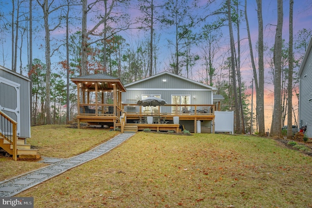 back of house with an outdoor structure, a yard, a wooden deck, and a gazebo