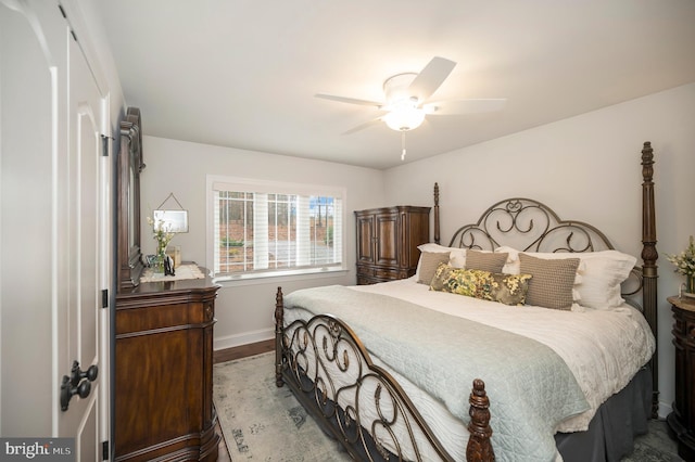 bedroom featuring ceiling fan, baseboards, and wood finished floors