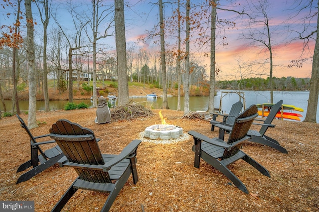 exterior space with an outdoor fire pit and a water view