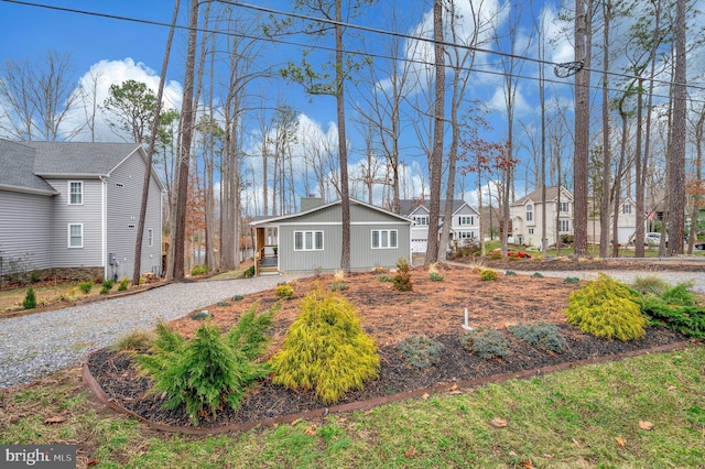 view of front of property with driveway, a chimney, and a residential view