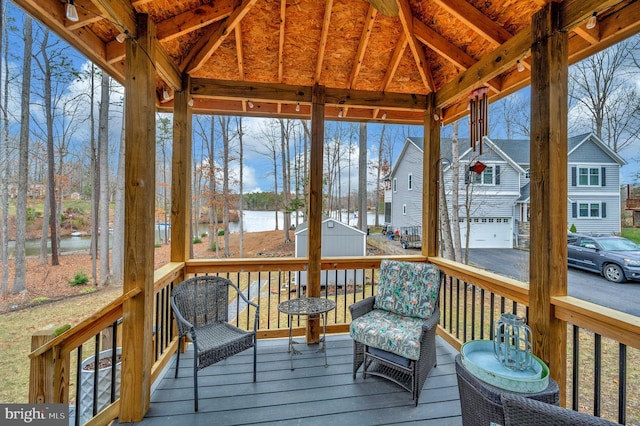 sunroom with lofted ceiling and a water view