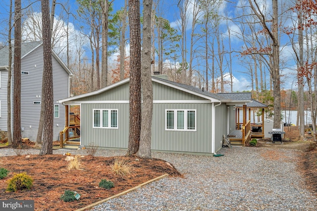 view of property exterior with a deck and roof with shingles