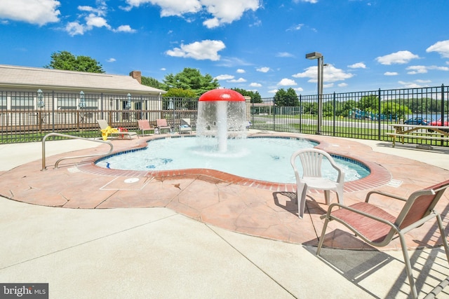 view of swimming pool featuring fence and a patio