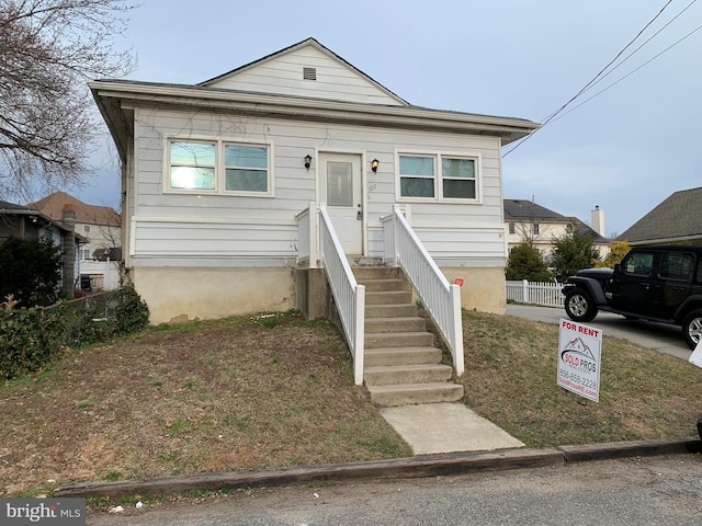 bungalow-style home featuring fence