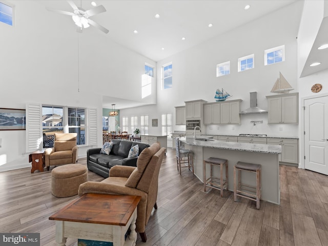 living area with recessed lighting, light wood-style floors, and ceiling fan