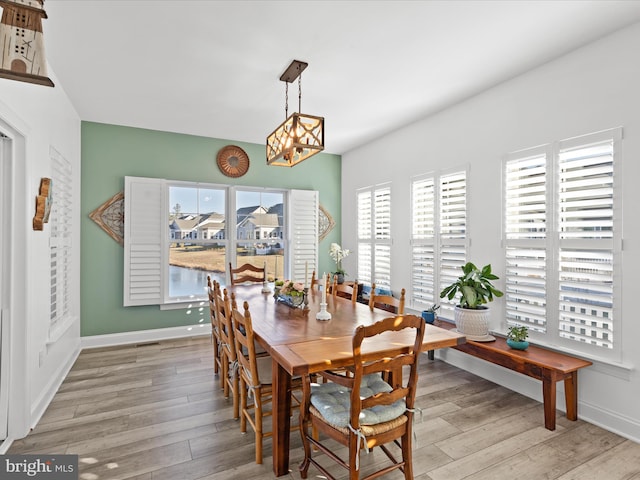 dining area with light wood-type flooring and baseboards