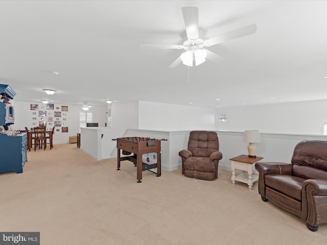 living area with a ceiling fan and light carpet