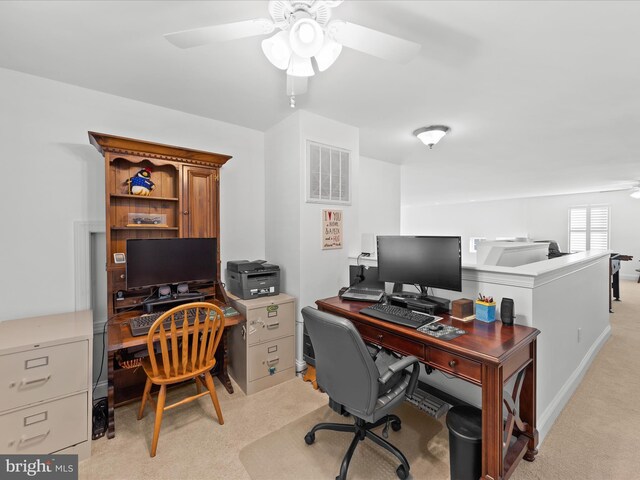 home office featuring light carpet, visible vents, and ceiling fan