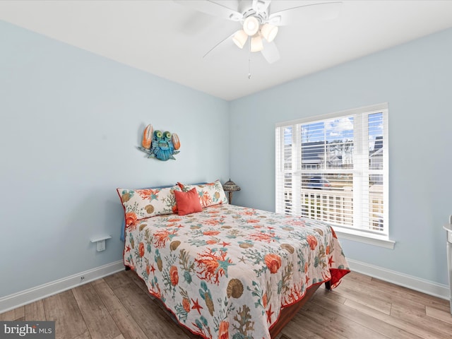 bedroom with baseboards, wood finished floors, and a ceiling fan