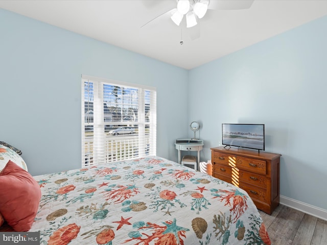 bedroom with ceiling fan, baseboards, and wood finished floors