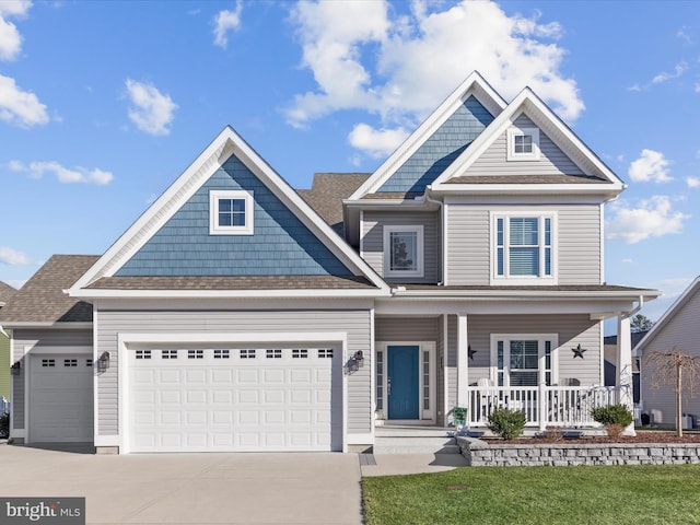 view of front of home with a garage, covered porch, and concrete driveway