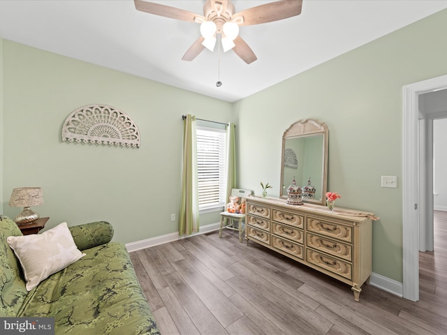 bedroom featuring a ceiling fan, baseboards, and wood finished floors