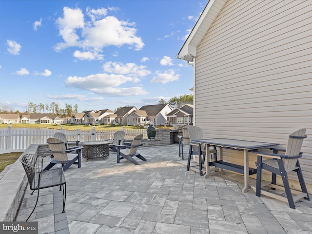 view of patio with a residential view, a fire pit, and fence